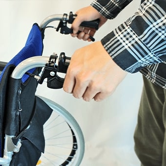 車椅子の介助用ブレーキをかける